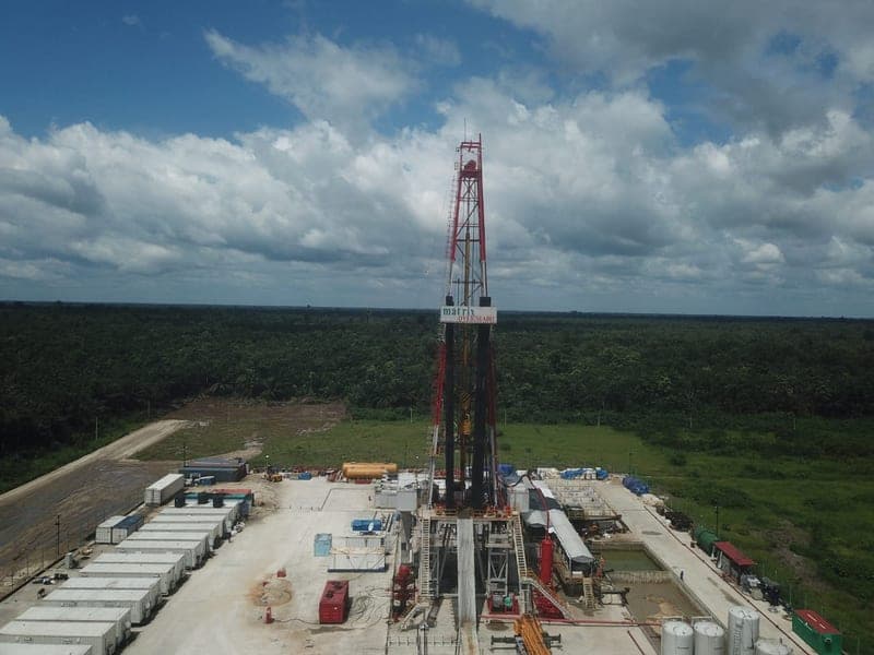 The Oyebisi A-001 rig mast against a storm cloud at the Atamba location